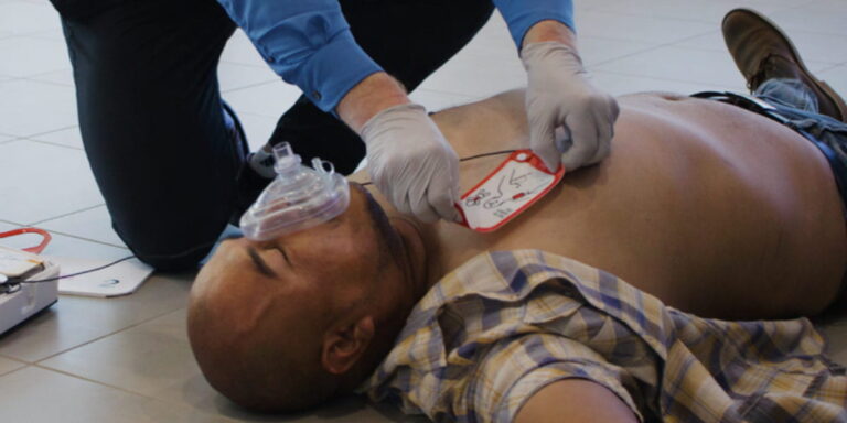 Bystanders performing CPR and using an AED to save a man during sudden cardiac arrest