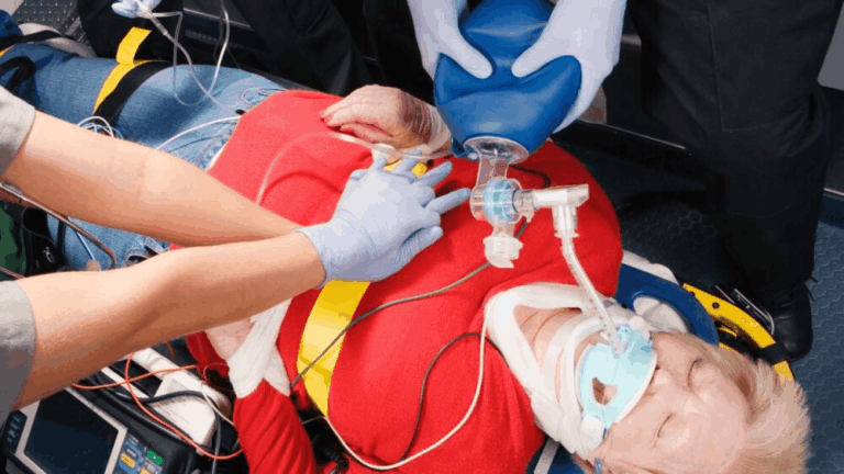 Paramedics providing emergency cardiac care using a defibrillator and airway support after sudden cardiac arrest