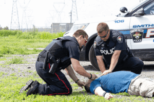 Police officers performing CPR on a man during a medical emergency to save his life