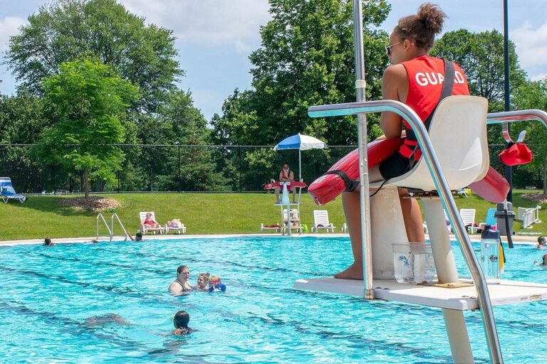 Lifeguard monitoring public swimming pool during emergency