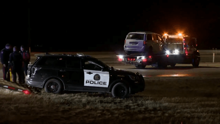 Calgary police vehicle at night during Forest Lawn homicide investigation as emergency crews secure the scene
