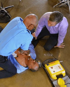 Emergency responders provide life-saving treatment using an AED and CPR on a man during an emergency.