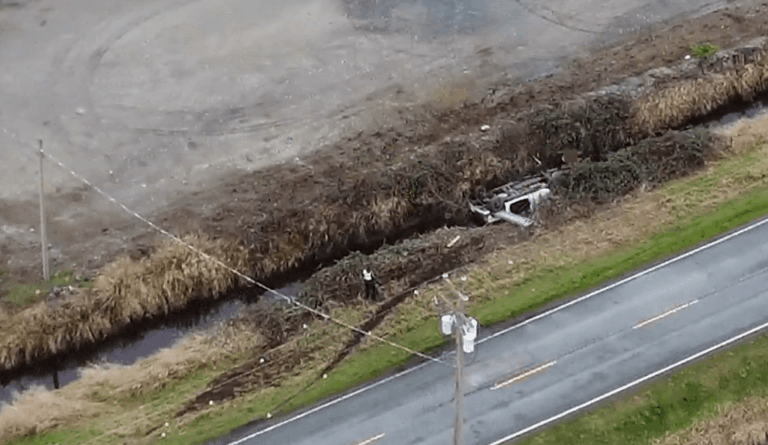 Overturned vehicle submerged in a water-filled ditch following a serious crash in Surrey, British Columbia.