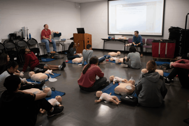 Students receiving CPR and AED training during a mandatory first aid class at a Montreal school