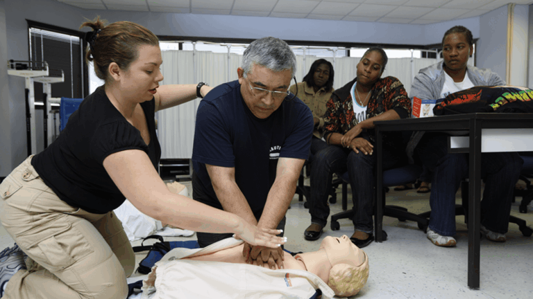 Students practicing CPR on a training manikin during a first aid class